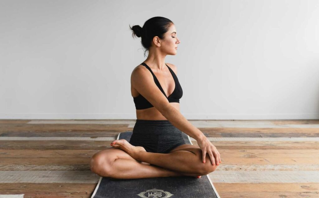 A female in black crop top and matching shorts in a yoga pose. For the Safe and effective relaxation techniques section.