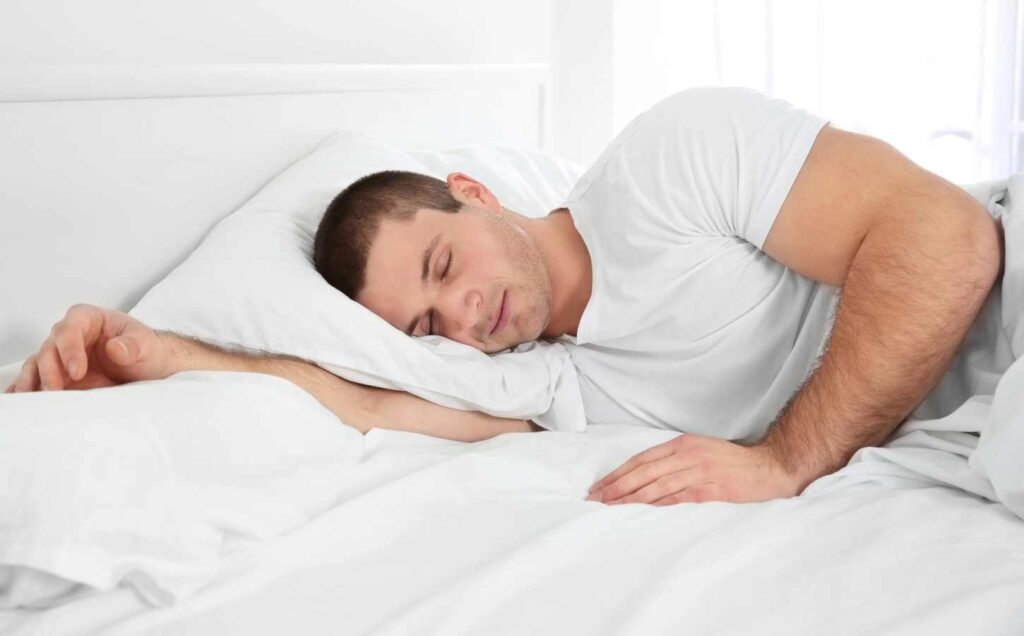 A young man sleeping on his side to avoid central sleep apnea.