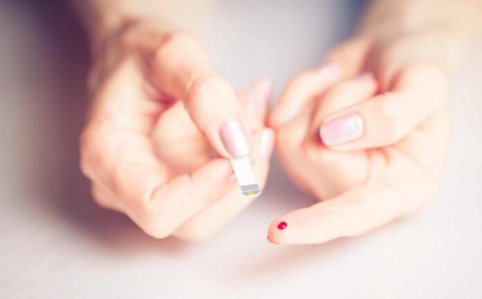 Close up of female finger with blood drop from diabetic test kit.