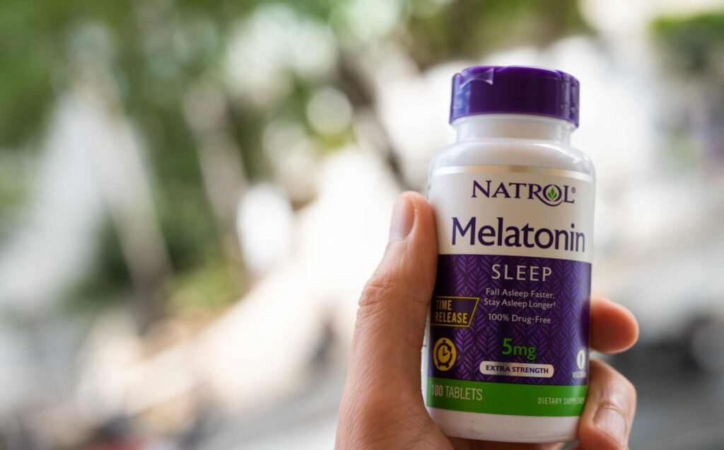 A person holding up a bottle of Natrol Sleep Melatonin 5mg Fast Dissolve Tablets