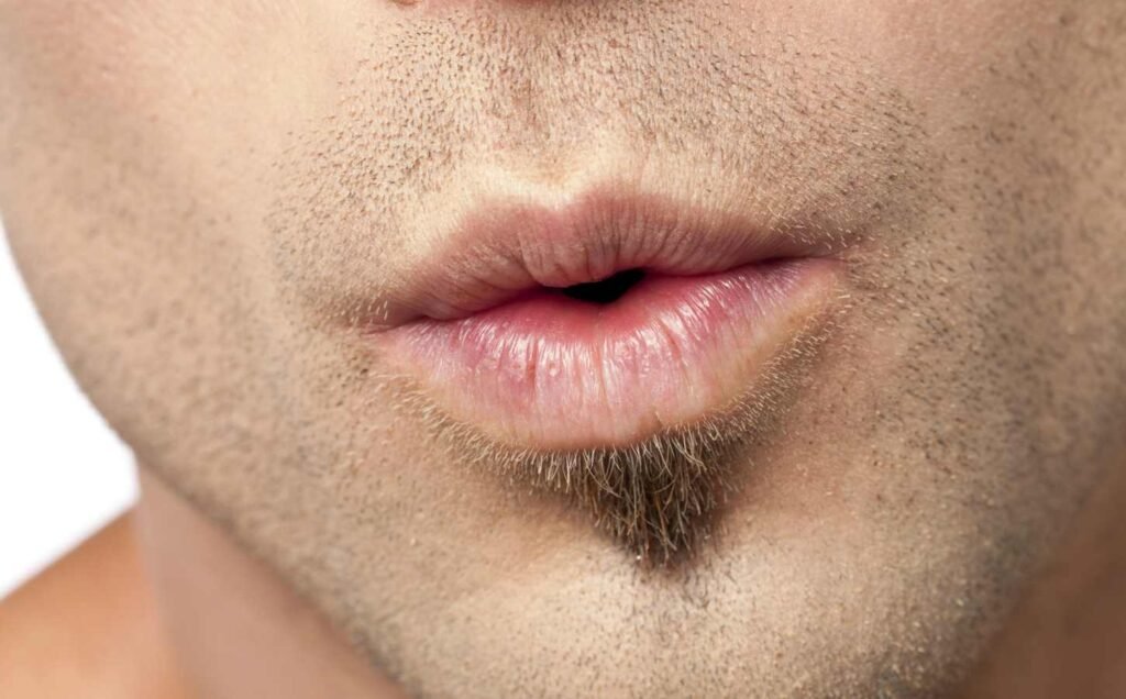 Close up of mans lips blowing, practicing the 4-7-8 breathing technique.