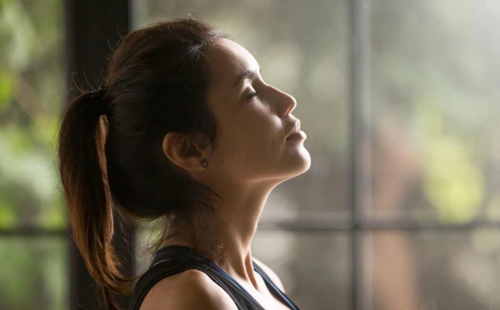 Side on portrait of a woman practicing the 4-7-8 breathing technique.