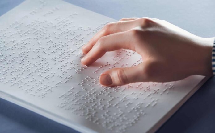 Close up view of blind woman reading braille text with hand.