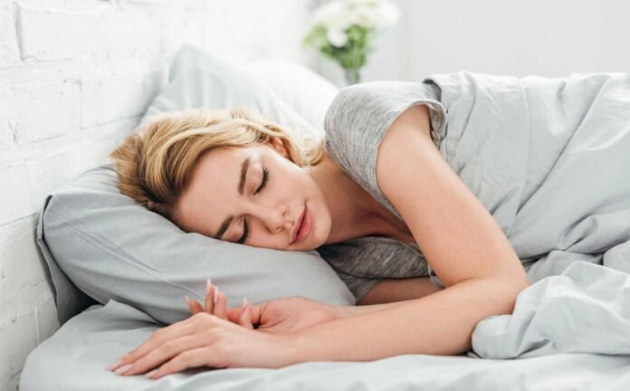 A woman asleep in bed experiencing Stage 2 Non-Rapid Eye Movement Sleep.