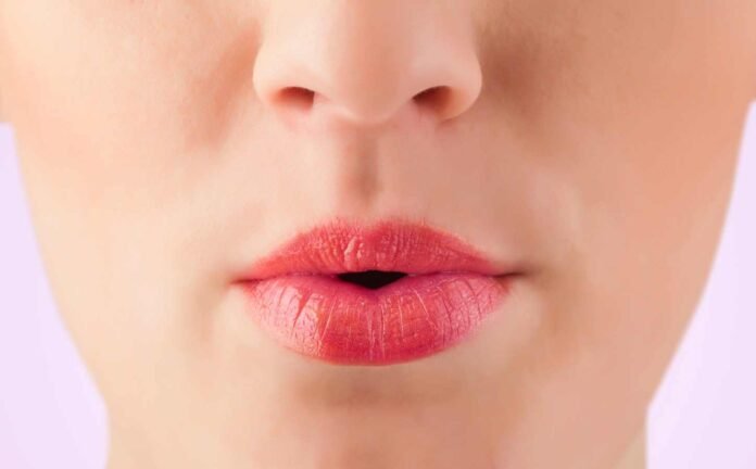 Close up of a woman's red lips. She is performing a tongue trick for better sleep.