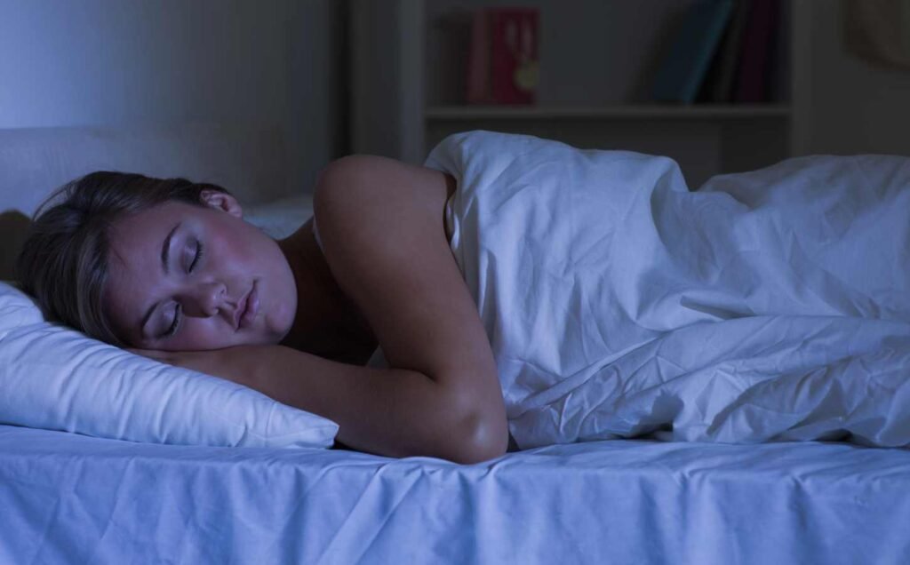 a woman in bed with white sheets sleeping soundly.